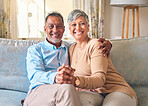 Senior couple, portrait and holding hands on sofa in home living room, bonding and love. Smile, elderly man and happy woman relax with romance, care and enjoying retirement together in house lounge.