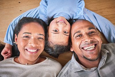 Buy stock photo Face, family and smile in home top view, bonding and having fun on floor in house. Portrait, parents and happy child, mother and father with love, relax on ground and enjoying quality time together.
