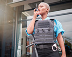 Police, walkie talkie and patrol with a black woman officer outdoor on a city street for law enforcement. Radio, communication and a female security guard talking during crime prevention for safety