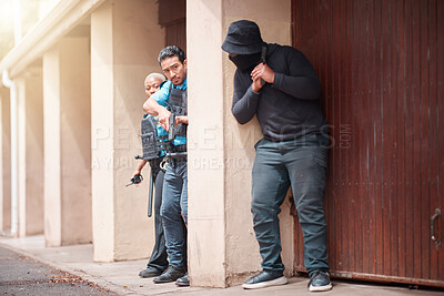 Buy stock photo Police, criminal and gun taking cover for security, backup or law enforcement outside house. Man, woman cop and dangerous robber with weapon in crime for justice, investigation or protection service