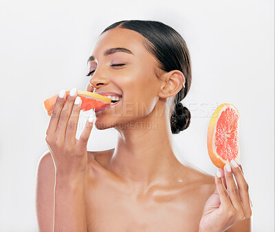 Buy stock photo Eating, grapefruit and Indian woman with natural beauty, skincare and cosmetics for healthy glow, citrus or vitamin c. Face, skin care and eat fruit for wellness, health of body and white background