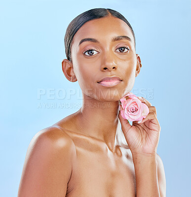 Buy stock photo Woman, rose and natural beauty with cosmetics and eco friendly skincare on blue background. Flower, nature and sustainable dermatology with skin glow, female model and portrait in studio