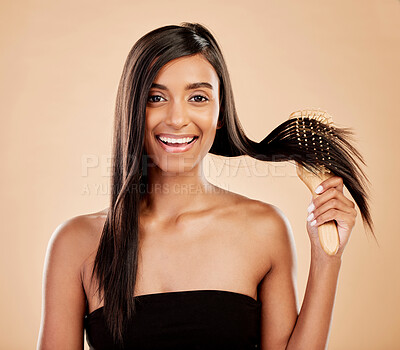 Buy stock photo Portrait, beauty and a woman brushing her hair in studio on a cream background for natural or luxury style. Haircare, face and shampoo with a young indian female model at the salon or hairdresser