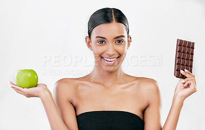 Buy stock photo Apple, chocolate and portrait of woman for healthy food choice, sugar and beauty isolated on studio white background. Dessert, green fruit and face of indian person detox, vegan or skincare decision