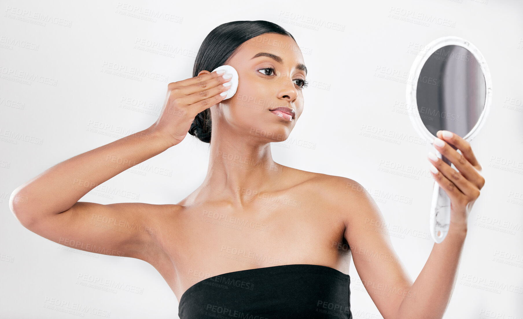 Buy stock photo Woman, mirror and cotton pad for face, cosmetics and aesthetic skincare in studio on white background. Indian female model looking at reflection with beauty product for facial cleaning or dermatology