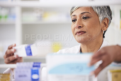 Buy stock photo Pharmacist, shelf and a woman with a medicine box in a pharmacy for inventory or prescription. Mature female employee in healthcare, pharmaceutical and medical industry reading product information