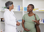 Pregnant woman, doctor and consultation at pharmacy for checkup or healthcare advice at drug store. African female person in maternity talking to medical professional for pharmaceutical at the clinic