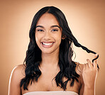 Portrait, hair and beauty with a model woman in studio on a brown background for shampoo treatment. Smile, salon and haircare with a happy young person looking confident about natural cosmetics