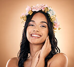 Portrait, beauty and flower crown with a model woman in studio on a brown background for shampoo treatment. Smile, salon and hair with a happy young person looking confident about natural cosmetics