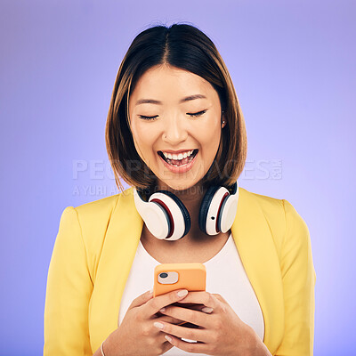 Buy stock photo Headphones, phone and happy Asian woman in studio smile for social media, internet meme and chat. Texting, smile and female person on smartphone listen to audio, song and track on purple background