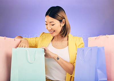 Buy stock photo Check, shopping bag and happy woman for fashion sale, discount or retail prize on studio, purple background. Happy young model, asian person or customer with choice, giveaway and rich, wealth or gift