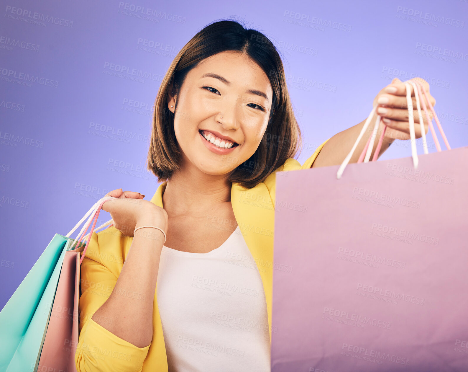 Buy stock photo Shopping bag, portrait and woman offer for fashion discount, deal or sale on studio, purple background. Giving, gift or competition of young customer, model or asian person, winning and retail prize