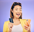 Credit card, phone and woman online shopping, e commerce or fintech payment on studio purple background. Excited, loan and happy asian person for internet banking, subscription or mobile transaction