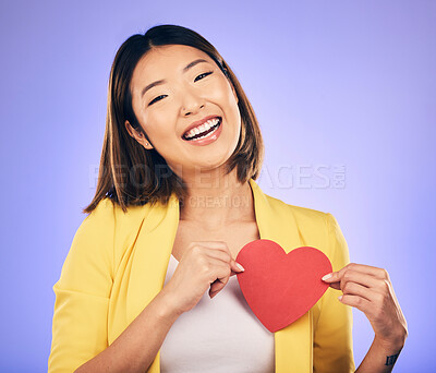 Buy stock photo Girl, smile and heart for care in portrait for purple background in studio with asian on valentines day. Support, love and chest with female person with happiness with emoji shape or emotion.