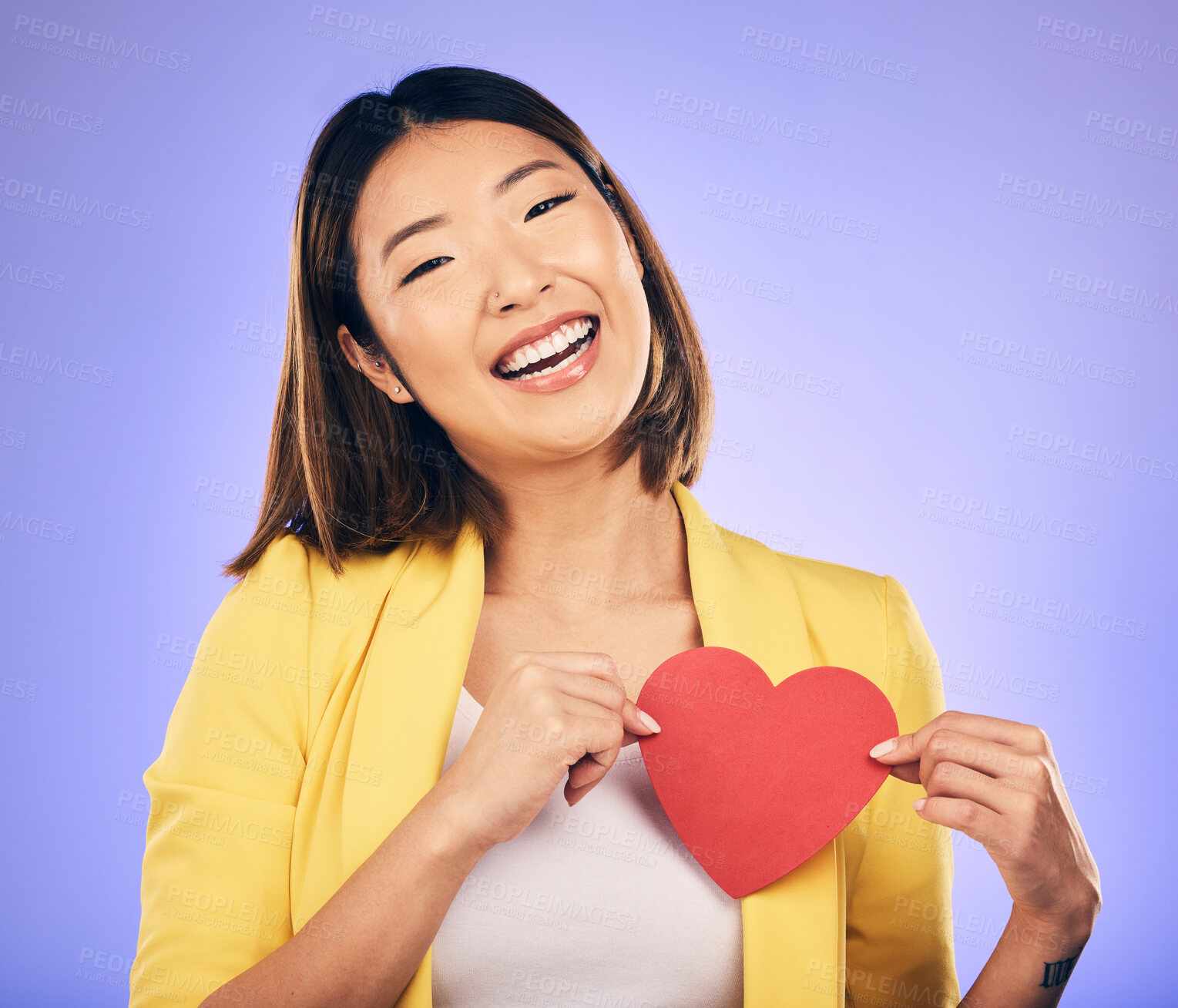 Buy stock photo Girl, smile and heart for care in portrait for purple background in studio with asian on valentines day. Support, love and chest with female person with happiness with emoji shape or emotion.