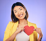 Support, asian girl and care with paper heart with portrait in purple studio or background with emotion. Woman, happy and face with love sign for peace or kindness with emoji shape for hope or smile.