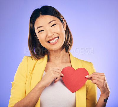 Buy stock photo Support, asian girl and care with paper heart with portrait in purple studio or background with emotion. Woman, happy and face with love sign for peace or kindness with emoji shape for hope or smile.