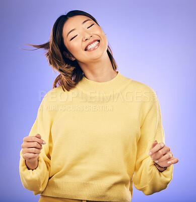 Buy stock photo Happy asian woman, dancing and enjoying music, freedom or casual fashion against a purple studio background. Female person or model smile for energy, event or party in happiness for clothing style