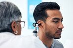 Ear check, man and clinic doctor with patient consultation for hearing and wellness at hospital. Senior, employee and otoscope test of physician with health insurance and consulting exam with expert