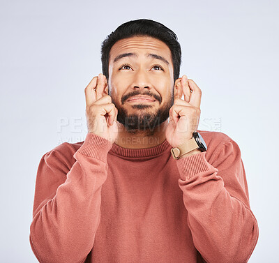 Buy stock photo Fingers crossed, hope and man with hands for good luck, anxiety or trust for bonus on white background in studio. Nervous asian male person wish for belief, emoji and prayer for winning lottery prize
