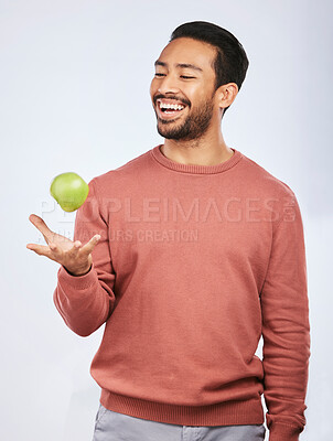 Buy stock photo Studio, fruit throw and happy man with apple product for self care diet, clean healthy gut or nutrition meal, vitamin or detox. Happiness, nutritionist food or hungry person smile on white background