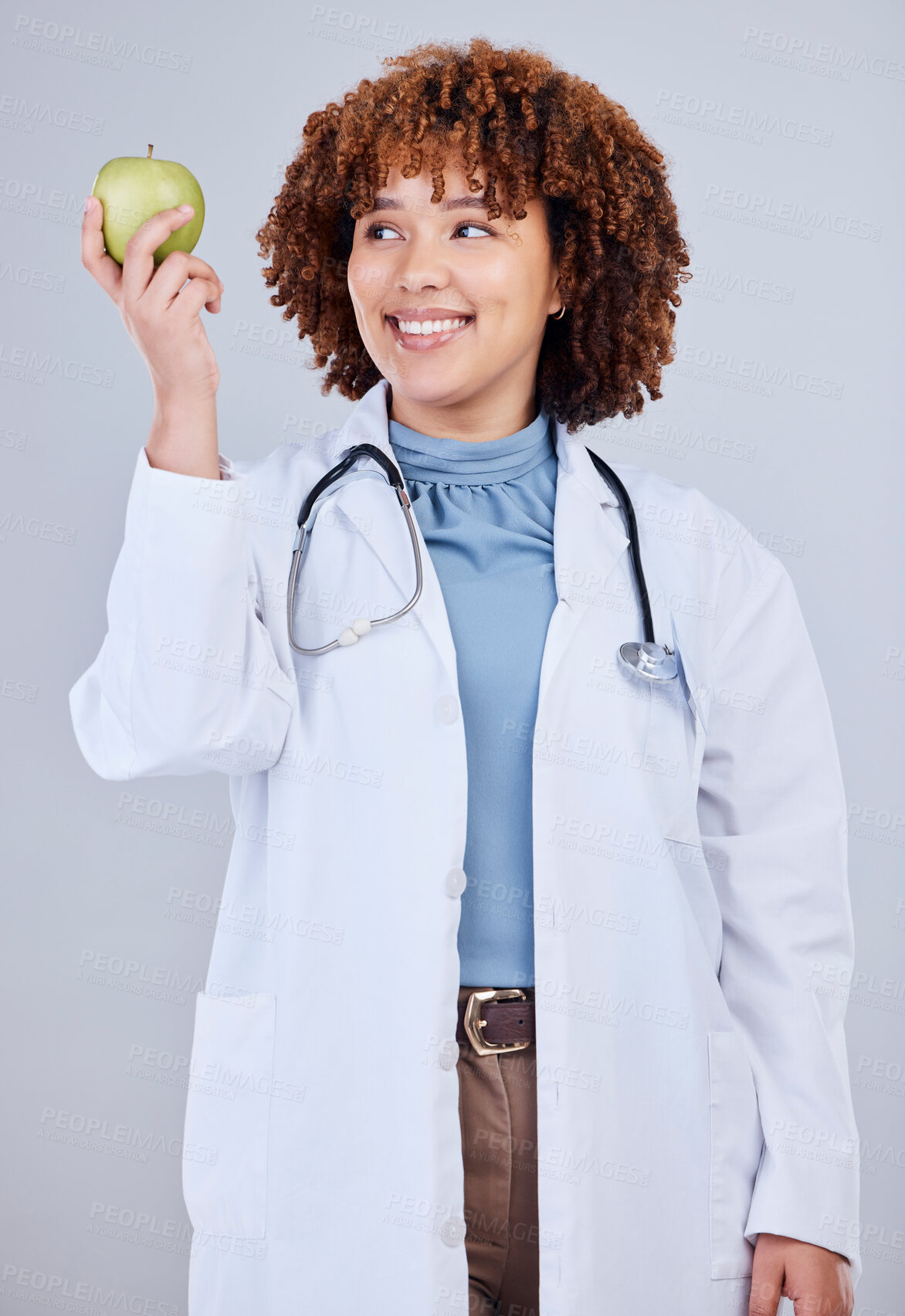 Buy stock photo Doctor, woman and smile with apple in white background, studio and vitamin c wellness. Happy female medical worker, nutritionist and advice of green fruits for nutrition, healthy food and detox diet