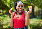 Happy black woman, orange slice and natural vitamin C for nutrition or citrus diet in nature outdoors. Portrait of African female person with organic fruit, food or fiber for healthy wellness in park