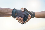 Teamwork, cycling and sports men shaking hands outdoor together against a sky background with flare. Handshake, fitness and partnership with a cyclist team saying thank you during a cardio workout