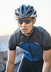 Man, mountain and cycling outdoor with sunglasses, helmet and speed for training, exercise and health in summer. Young cyclist athlete, focus and vision for race, performance and workout in sunshine