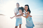 Beach, portrait and parents holding their child on the sand by the ocean on a family vacation. Happy, smile and girl kid flying and bonding with her young mother and father on tropical summer holiday