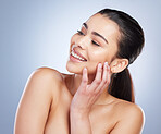 Happy, thinking and a woman with skincare glow for wellness, beauty or cosmetics. Smile, idea and a young model or girl touching skin for clean feeling and dermatology isolated on a studio background