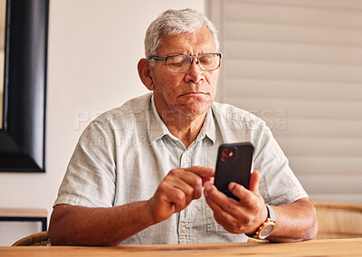 Buy stock photo Phone, social media and a senior man in his home, reading or typing a text message for communication. Mobile, contact and chatting with an elderly male pensioner sitting in his house for networking