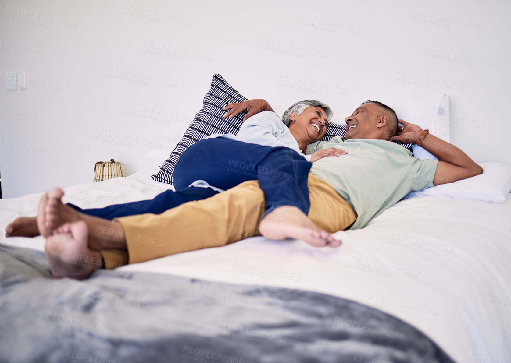 Buy stock photo Bed, relax and happy elderly couple laughing, resting and enjoy time together, cuddle and retirement wellness. Hug, home bedroom and senior man, old woman or people laugh, talking and in funny chat