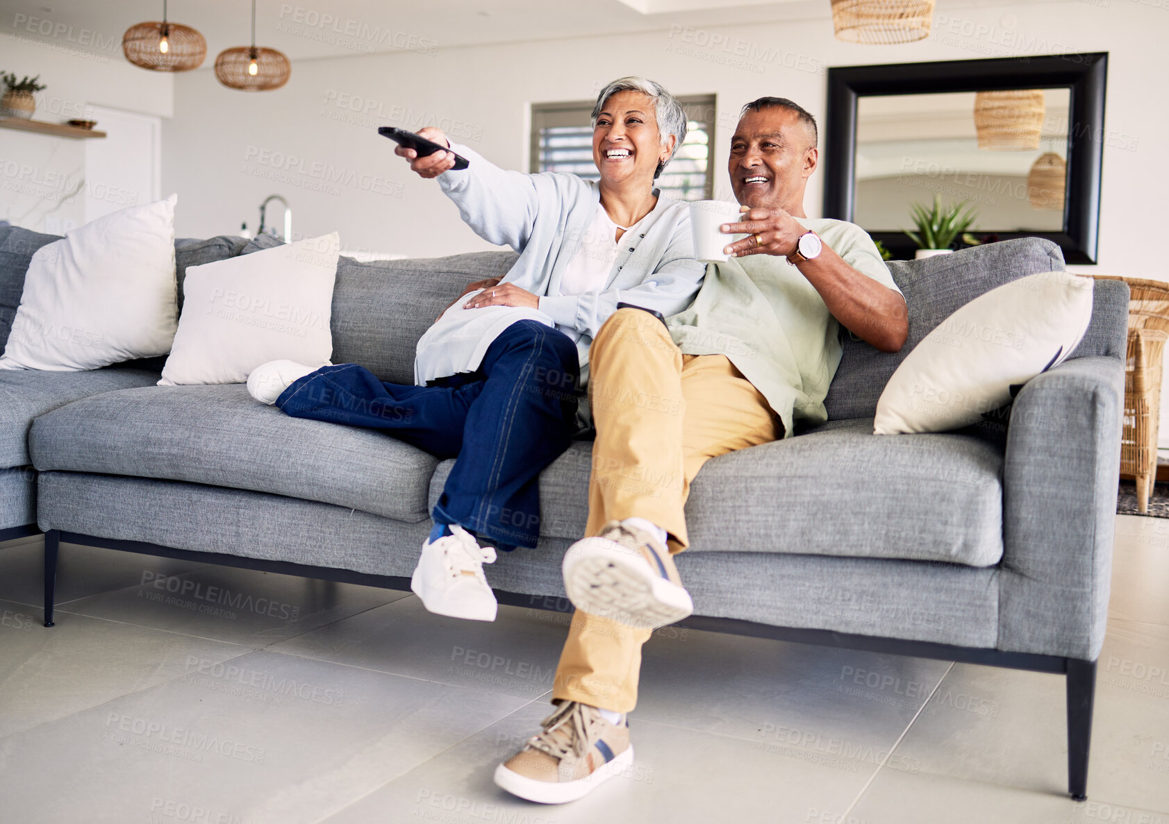 Buy stock photo Senior couple, watching tv and remote on sofa in home living room, laughing and smile for funny comedy show. Elderly man, old woman and relax together for video, comic movie and lounge couch in house