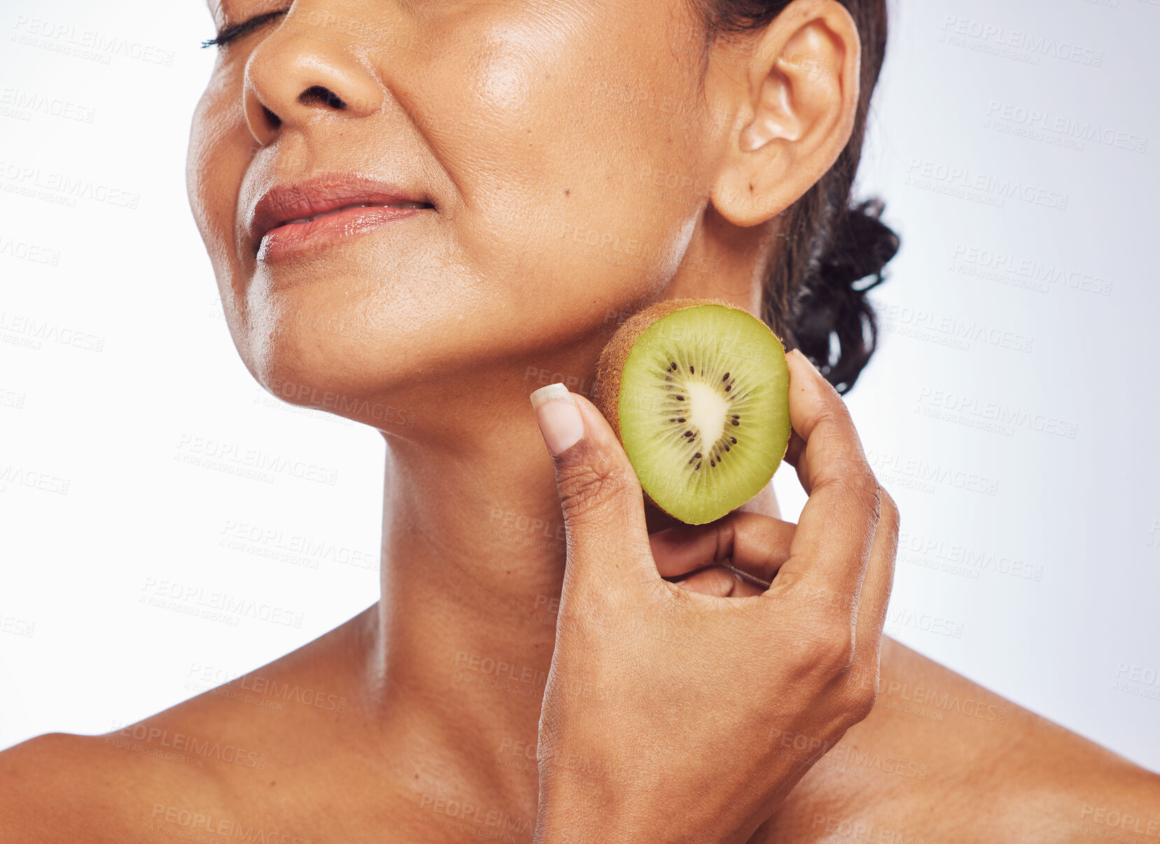 Buy stock photo Beauty, skincare and mature woman with kiwi in studio isolated on a white background. Food, fruit and natural model with nutrition for wellness, healthy diet and vitamin c for anti aging cosmetics.