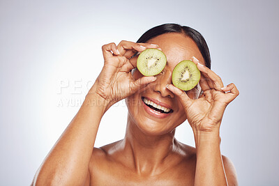 Buy stock photo Skincare, happy and senior woman with kiwi in studio isolated on a white background. Food, natural fruit and face of model with nutrition for wellness, healthy diet or vitamin c, anti aging or beauty