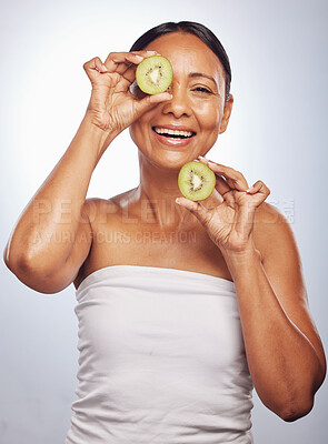 Buy stock photo Skincare, portrait and senior woman with kiwi in studio isolated on a white background. Food, natural fruit and face of happy model with nutrition for wellness, healthy diet and anti aging for beauty