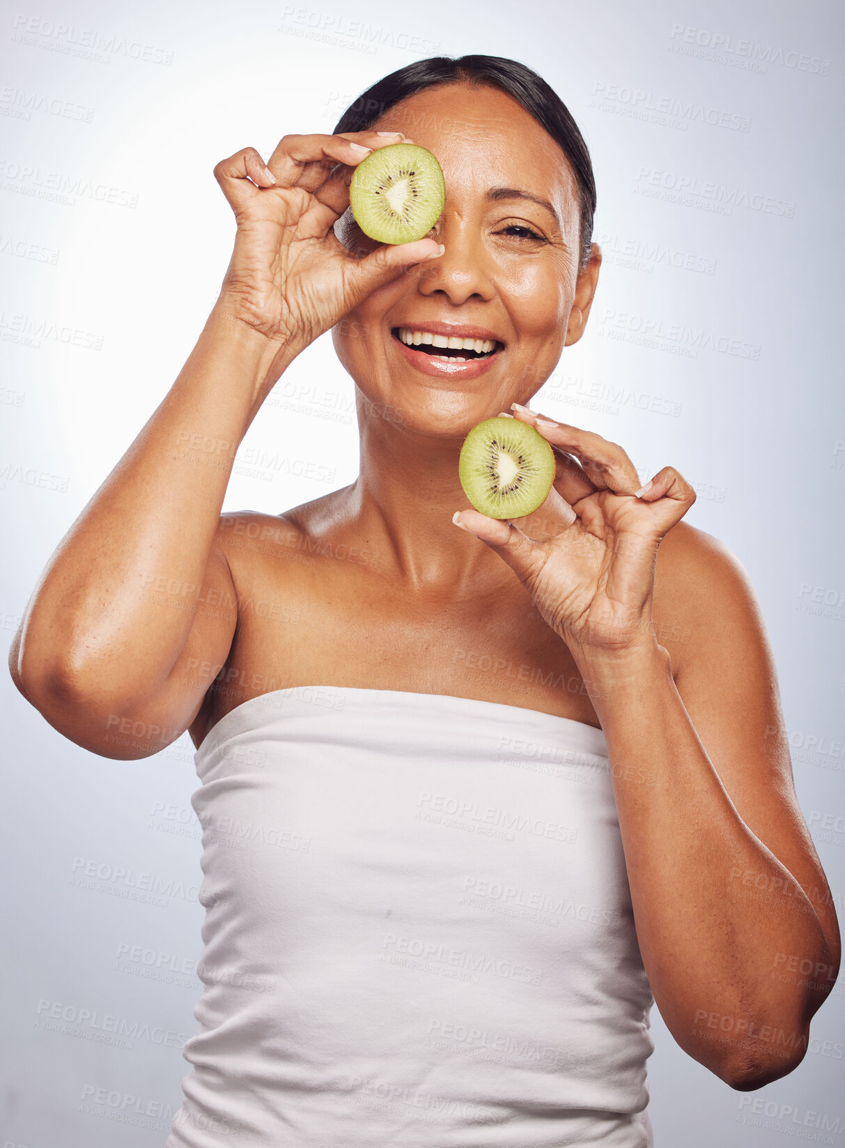 Buy stock photo Skincare, portrait and senior woman with kiwi in studio isolated on a white background. Food, natural fruit and face of happy model with nutrition for wellness, healthy diet and anti aging for beauty