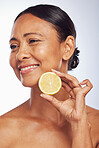 Thinking, orange and senior woman with skincare, dermatology and treatment against a white studio background. Mature female person, happy lady or model with citrus fruit, natural beauty and vitamin c