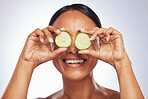 Cucumber, face and beauty of woman in studio, white background and aesthetic glow. Happy female model, natural skincare and fruits on eyes for sustainable cosmetics, vegan dermatology and nutrition