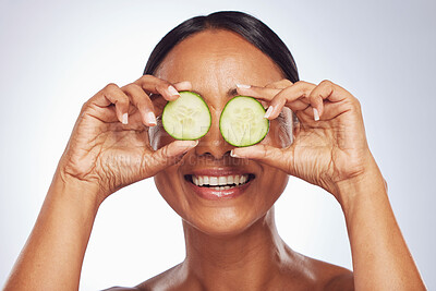 Buy stock photo Cucumber, face and beauty of woman in studio, white background and aesthetic glow. Happy female model, natural skincare and fruits on eyes for sustainable cosmetics, vegan dermatology and nutrition