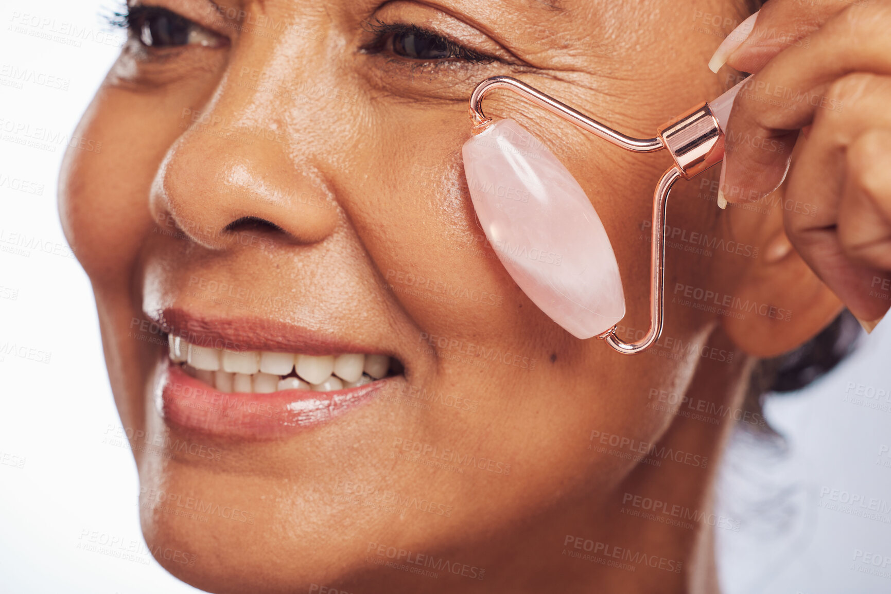 Buy stock photo Woman, face roller and massage for skincare, detox dermatology and aesthetic wellness in studio. Closeup of happy mature person, crystal stone tools and facial beauty cosmetics for lymphatic drainage