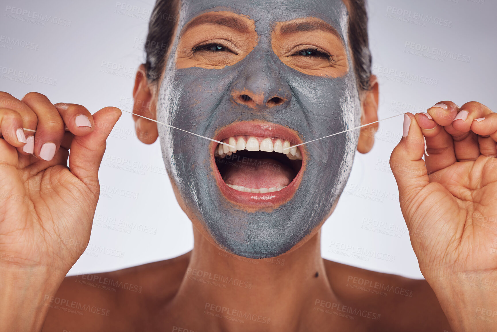 Buy stock photo Portrait, face mask and a woman flossing teeth for skincare, dental hygiene and wellness. Happy, cleaning and a model or girl with gear for tooth cleaning and a facial isolated on a studio background