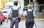 Police, people or walking in city for safety, law enforcement and urban patrol from the back. Man, woman and team of public service cops, metro security guard or protection in street together outdoor