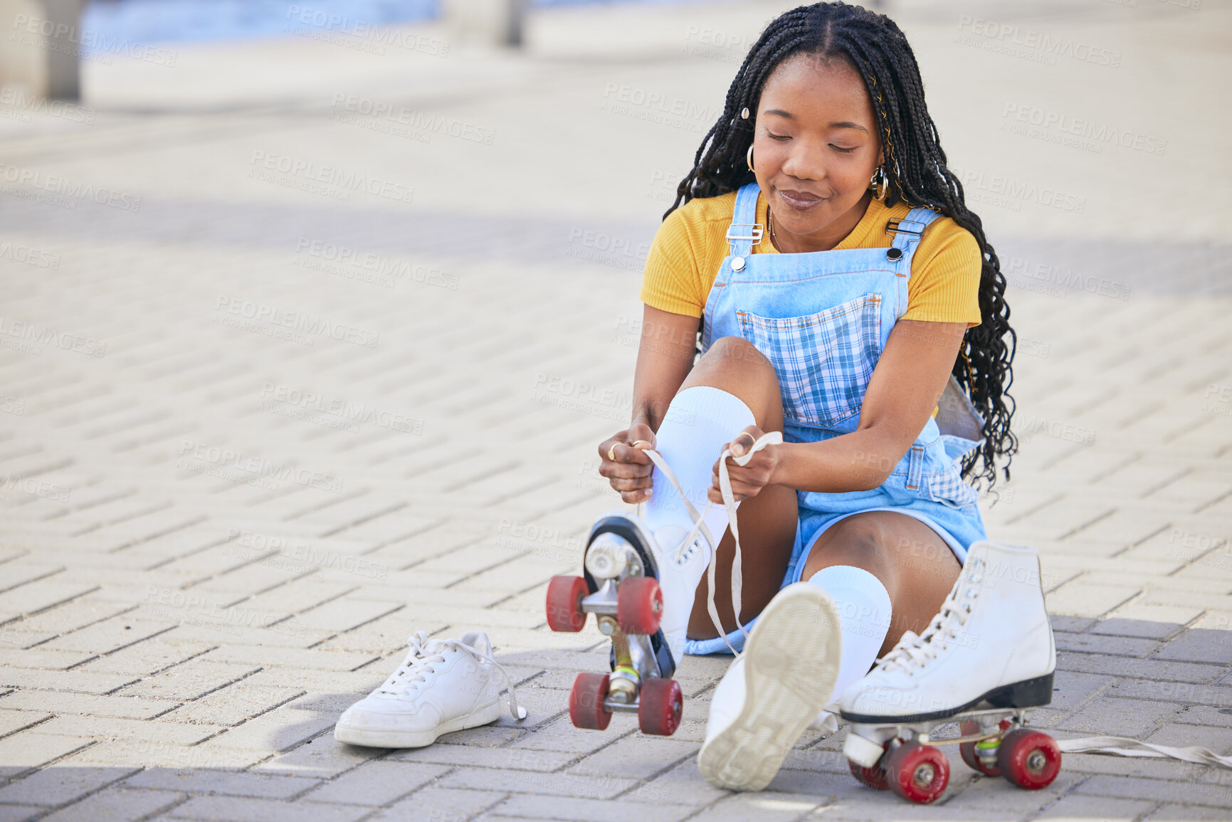 Buy stock photo Roller skating, tie and safety with a black woman by the sea, on the promenade for training or recreation. Beach, sports and a young female teenager tying skates on the coast by the ocean or water