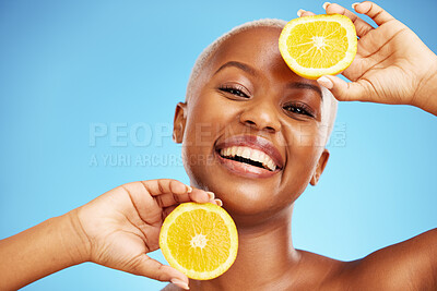 Buy stock photo Portrait, orange and beauty with a model black woman in studio on a blue background for nutrition. Smile, fruit and skincare with a happy young person holding a snack for natural health or wellness