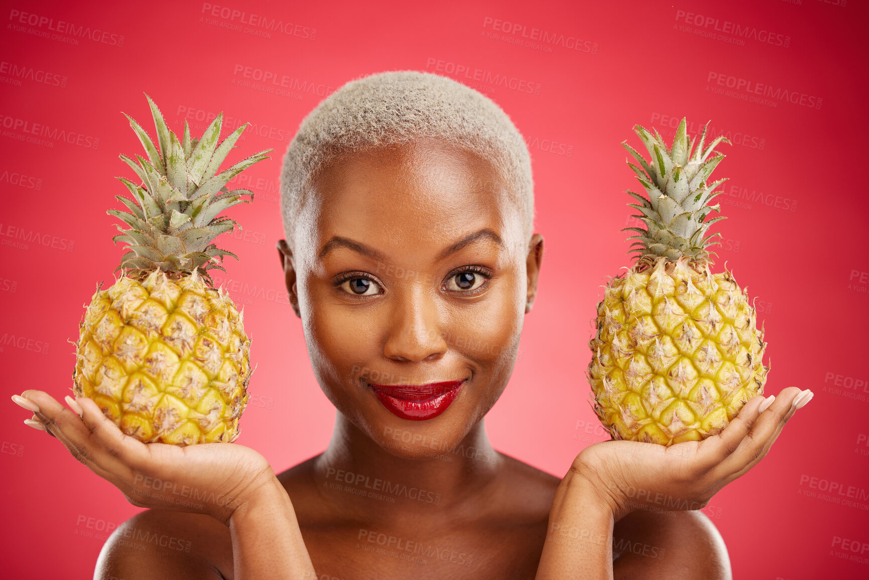 Buy stock photo Woman, pineapple and studio portrait for skincare, beauty and diet for wellness, health and red background. African model girl, fruits and face with makeup, nutrition and food choice with cosmetics