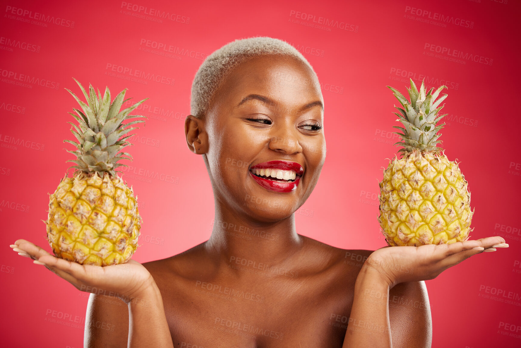 Buy stock photo Pineapple, beauty and face of a woman in studio for healthy food, diet or fruit. Black female model with makeup on red background for wellness glow, natural cosmetics and tropical or citrus skin care