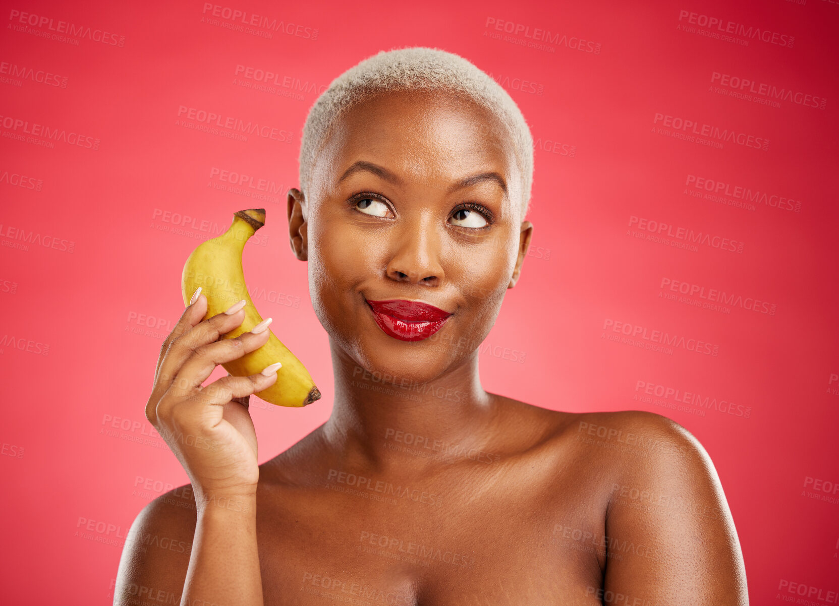 Buy stock photo Beauty, phone call and woman with a banana or acting angry, pretending and fake conversation on red background. Playful mobile communication, studio and girl with crazy and funny chat with fruit