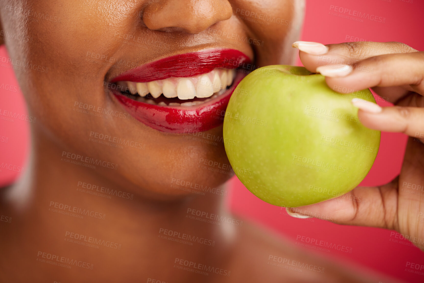 Buy stock photo Woman, mouth and apple for natural nutrition, diet or health and wellness against a red studio background. Closeup of female person smile with lipstick and organic fruit for vitamin, fiber or food